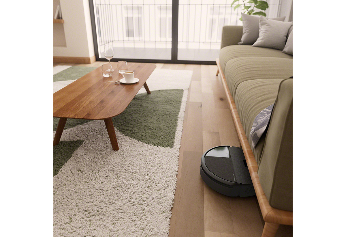 Παρουσιάζεται η σκούπα να καθαρίζει το πάτωμα ενός σαλονιού με χαλιά.